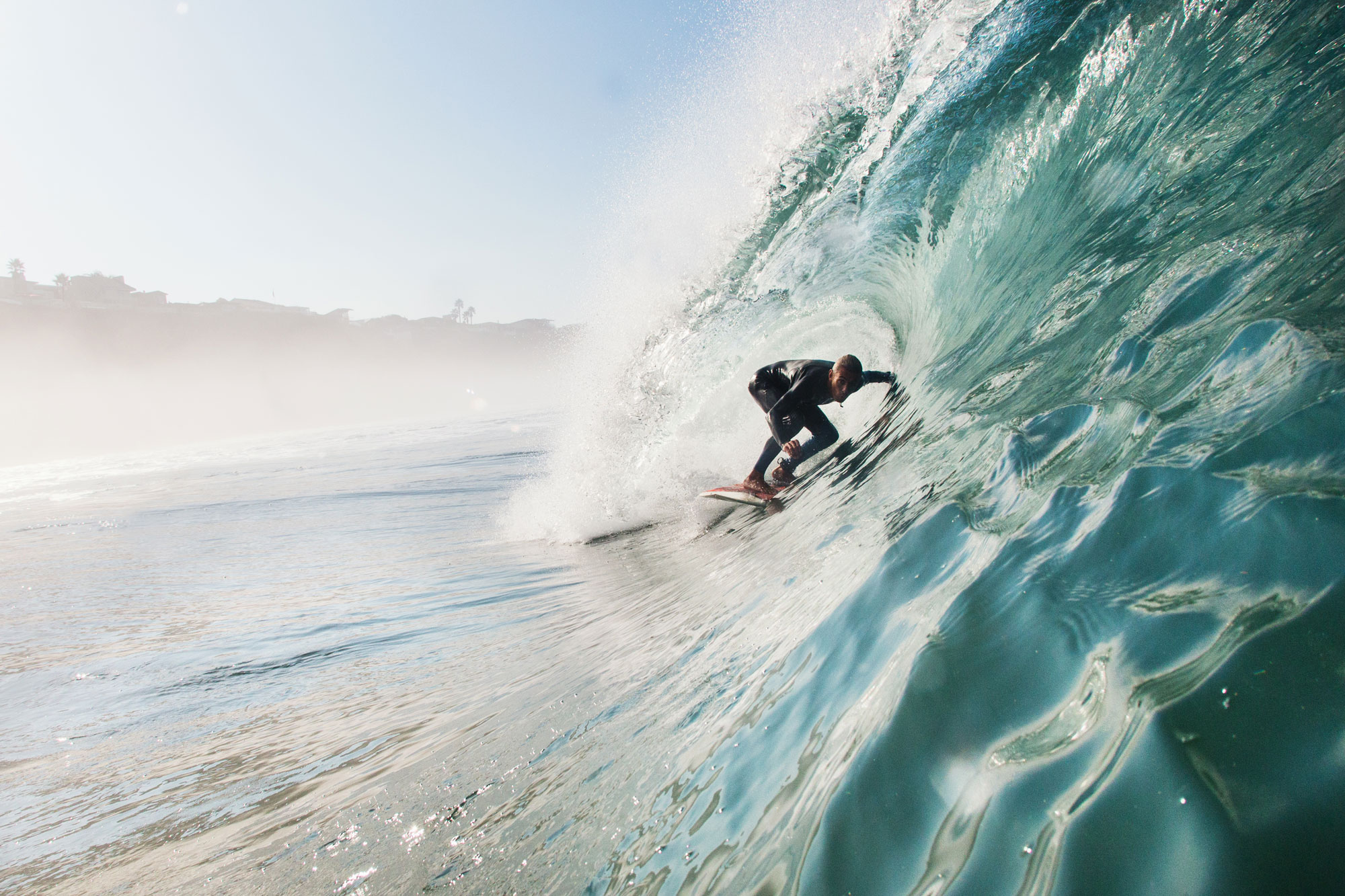 Man surfing a rolling wave with surf travel insurance.