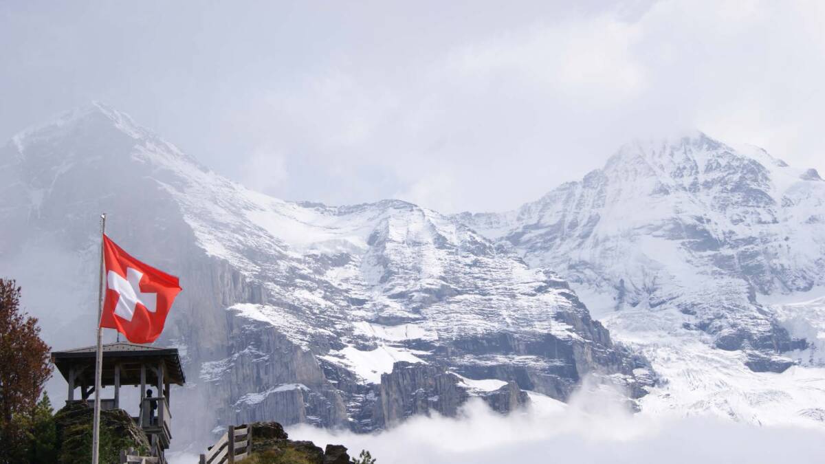 Switzerland Flag on Snowy Mountains Landscape.